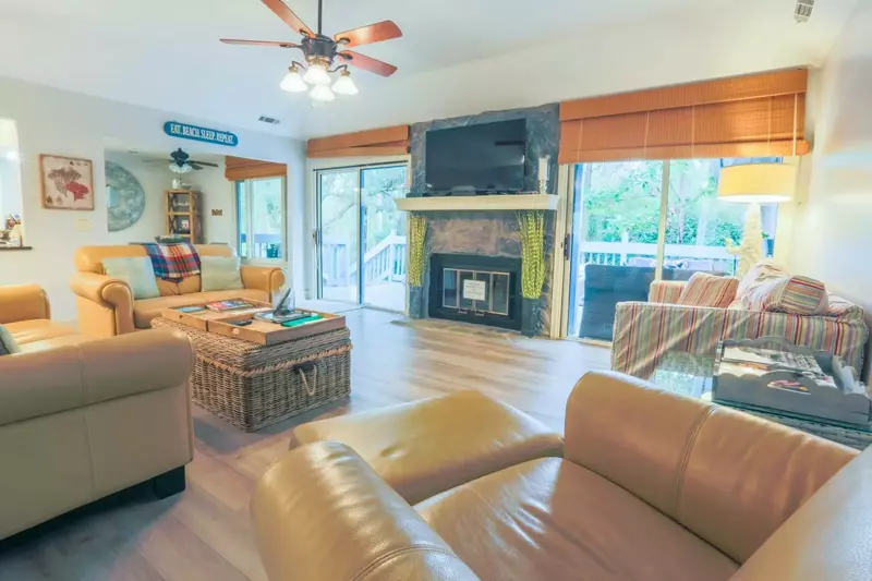 The home has a spacious, comfortable living room with two sets of sliding doors to the back porch.