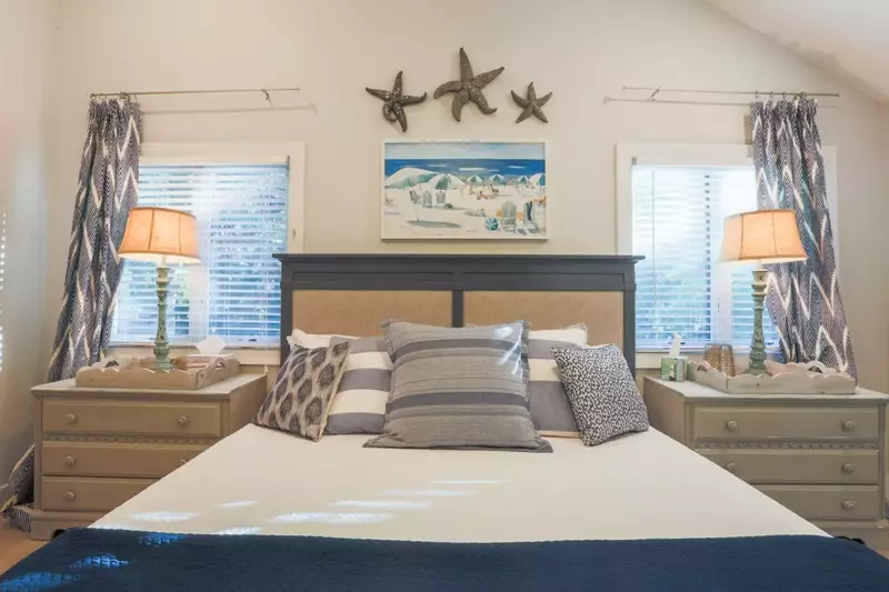 This master suite features a king bed and two night stands with reading lamps.
