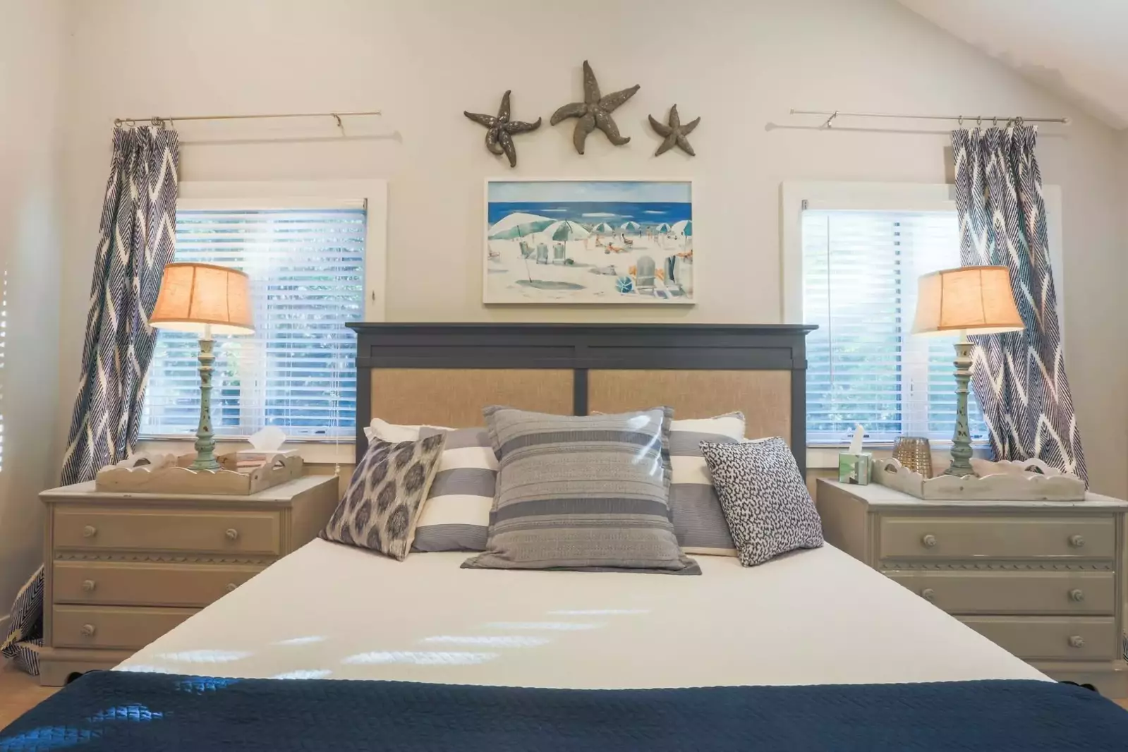 This master suite features a king bed and two night stands with reading lamps.