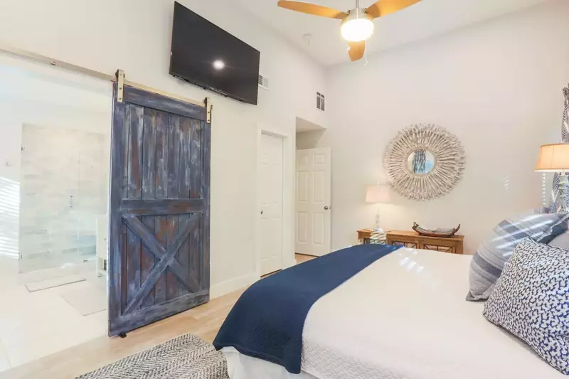 The en suite bathroom has a sliding barn door.