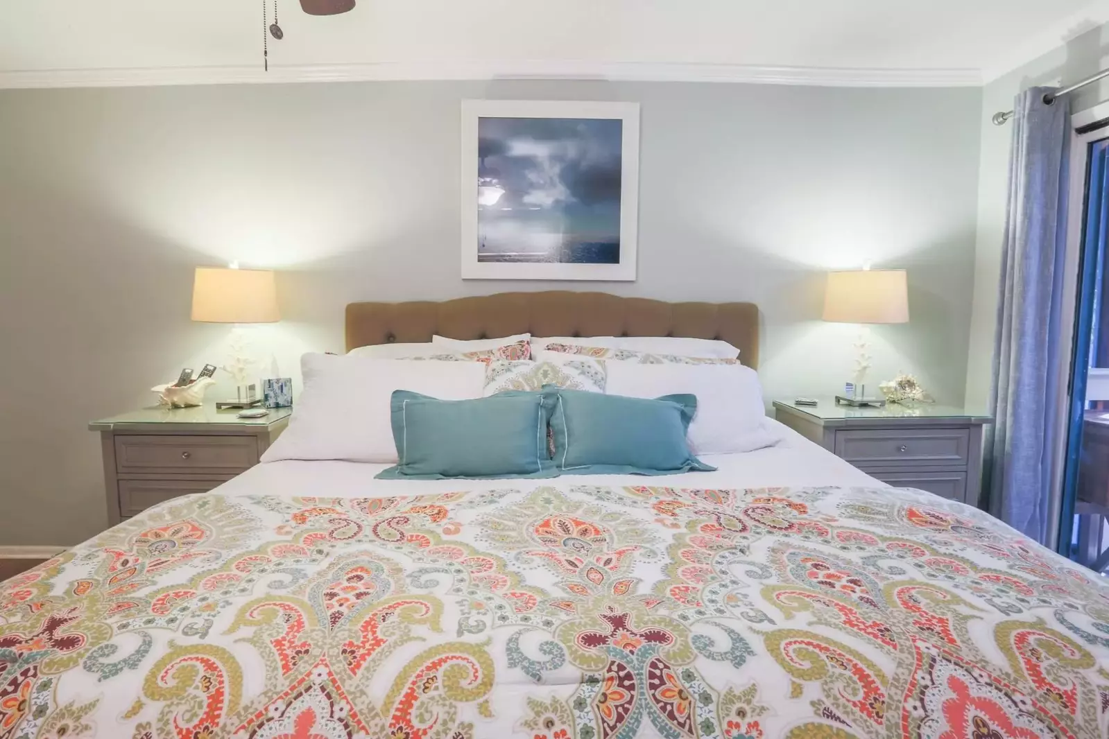 This master suite also features a king bed, two nightstands with reading lamps and a ceiling fan.