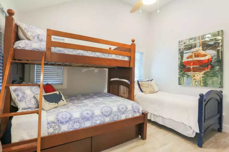 This guest bedroom features a bunk bed with full & twin beds.  There is also an additional twin bed.