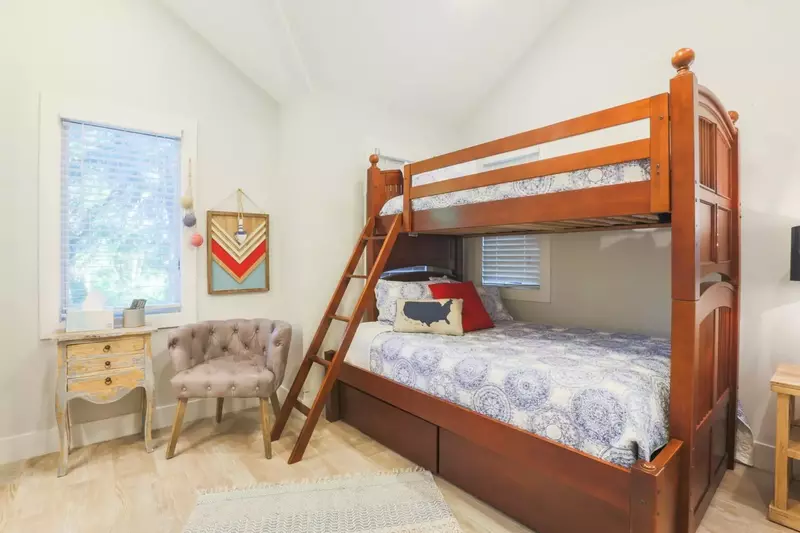 This room has elevated ceilings, a ceiling fan and a seating area.