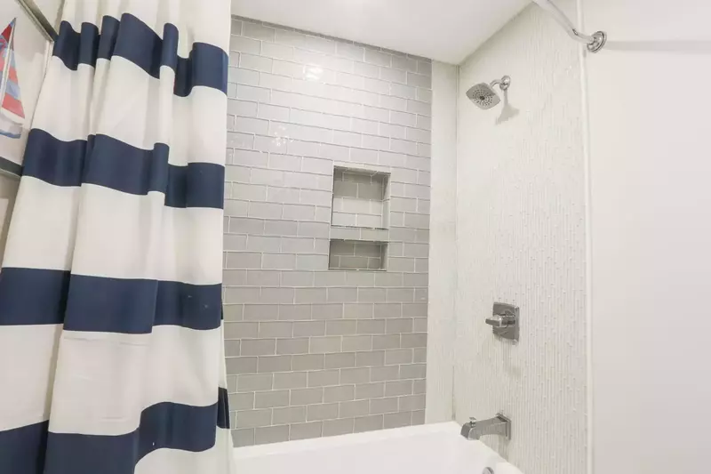 The en suite bathroom for the bunk bedroom has a beautifully tiled shower/tub combo.