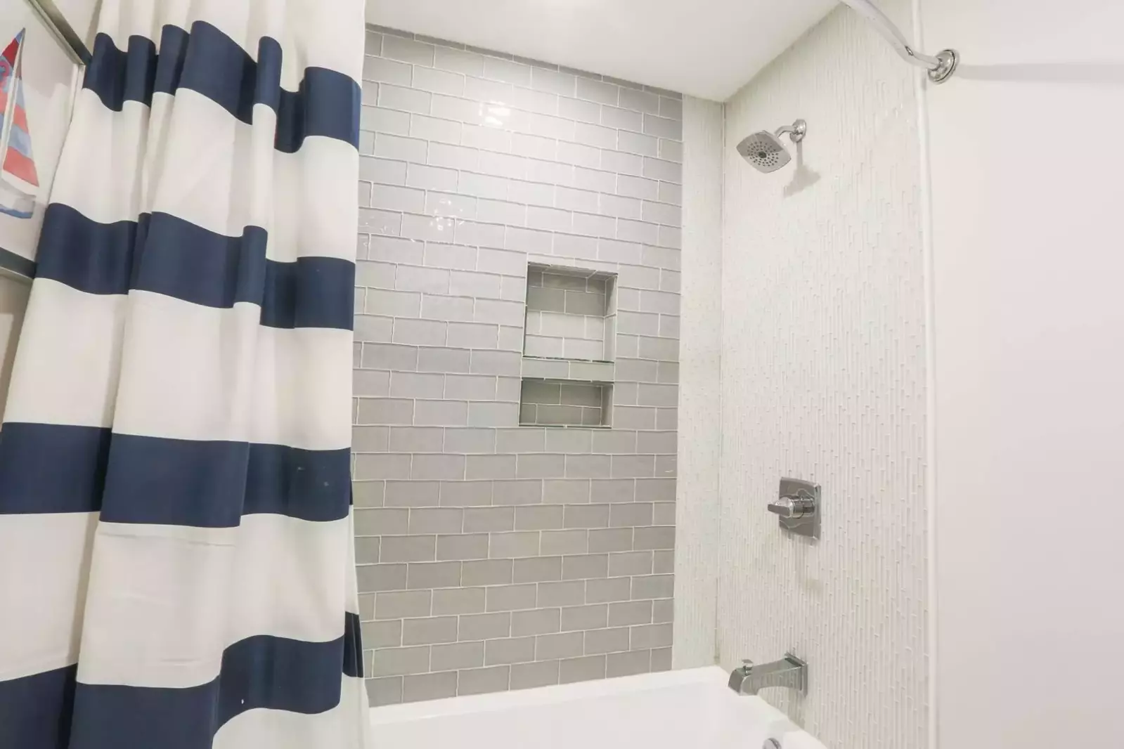 The en suite bathroom for the bunk bedroom has a beautifully tiled shower/tub combo.
