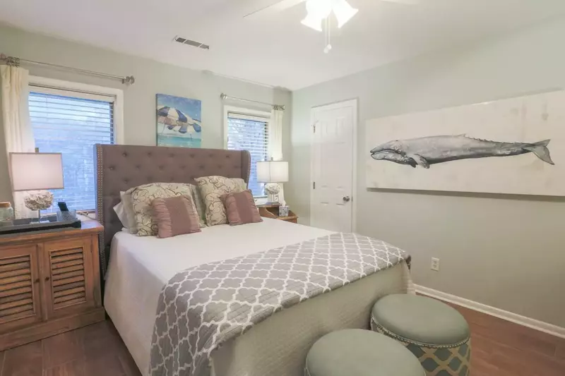 This guest bedroom has a queen bed, night stands with reading lamps and a ceiling fan.