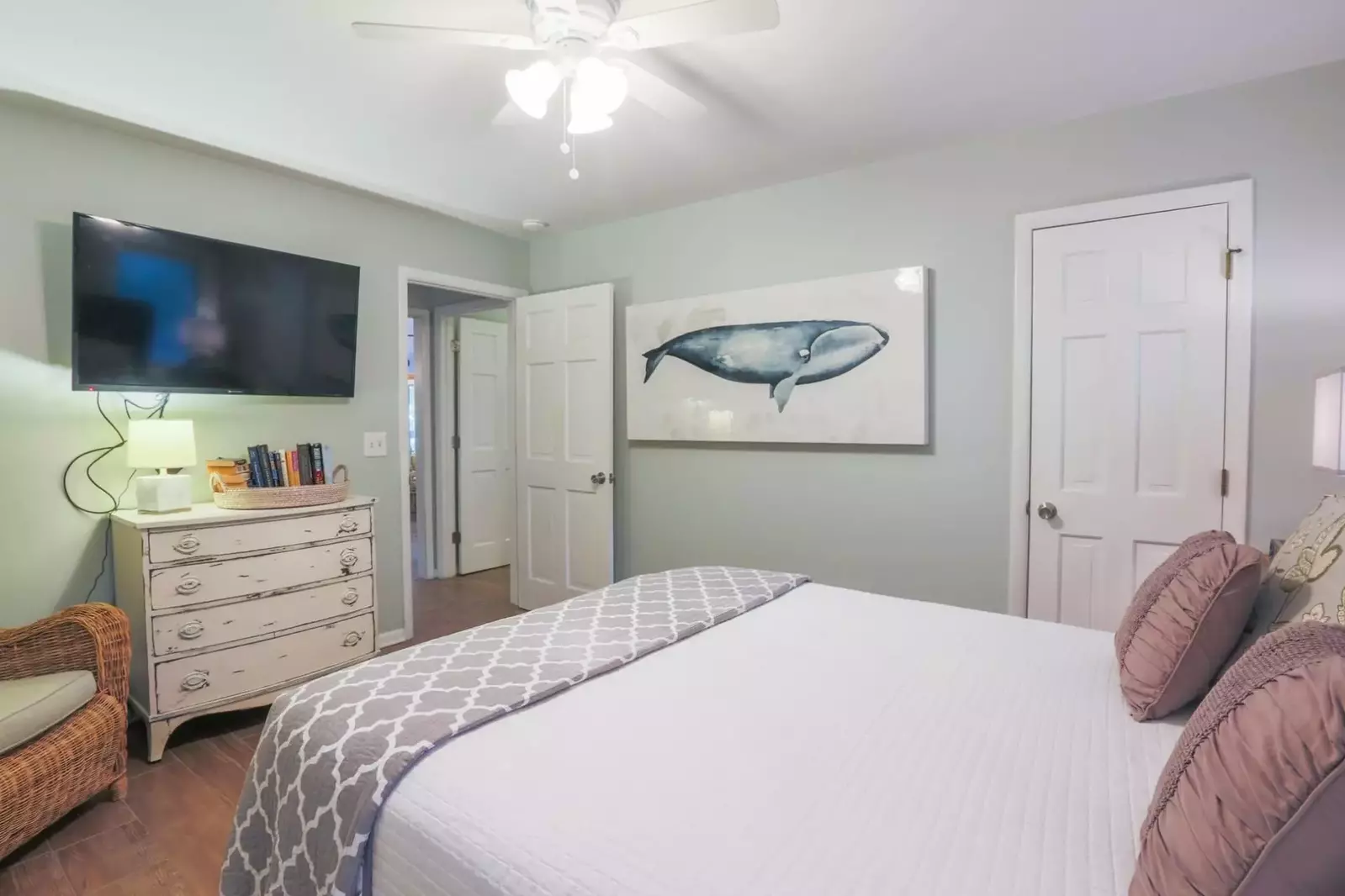 There is also a mounted, large screen TV and dresser within this guest bedroom.