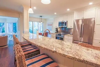 The curved breakfast bar with granite countertops separates the kitchen from the living room.