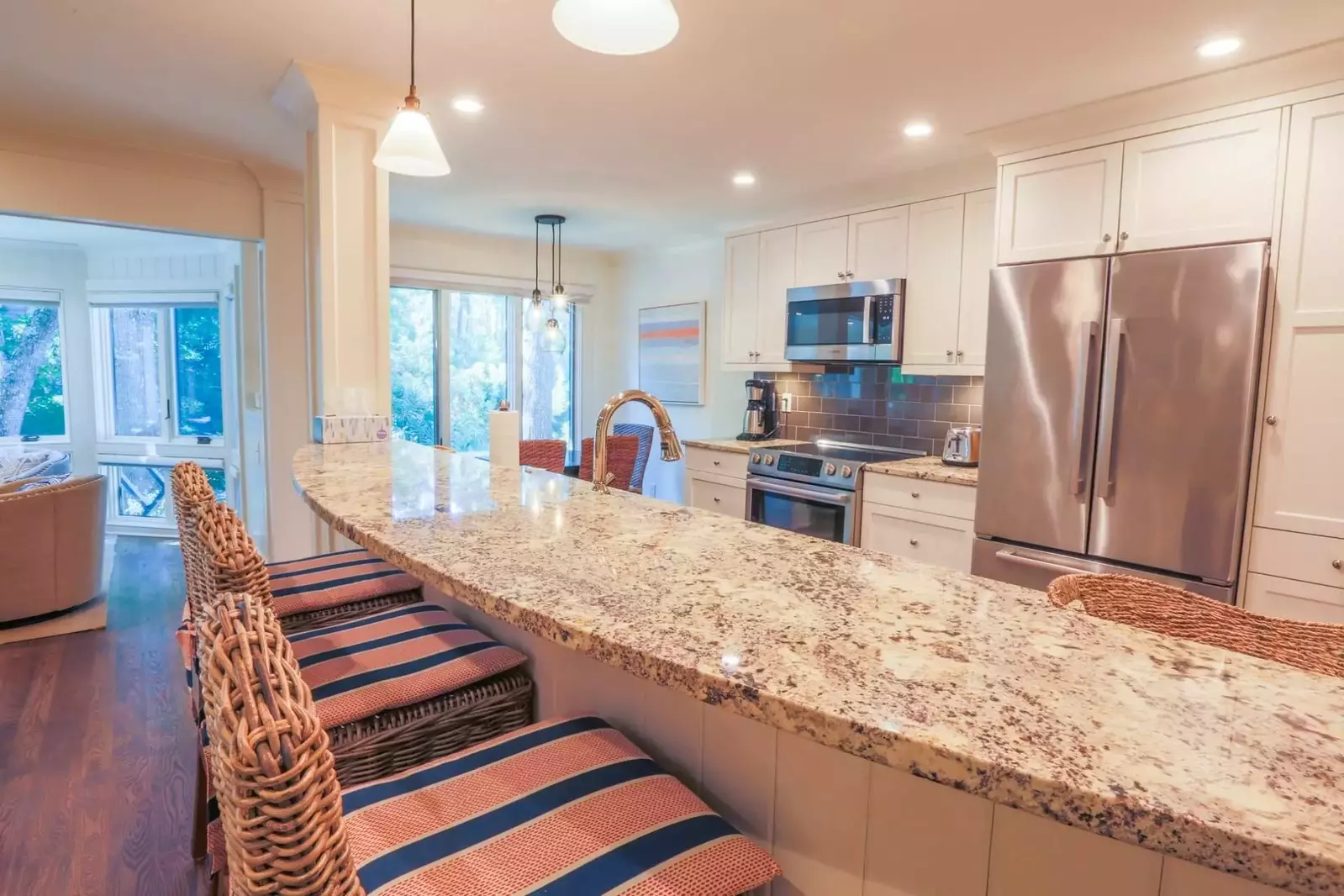 The curved breakfast bar with granite countertops separates the kitchen from the living room.