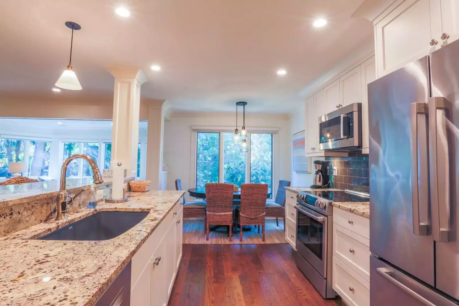 The kitchen features stainless steel appliances, a gray subway tile backsplash and hardwood floors.