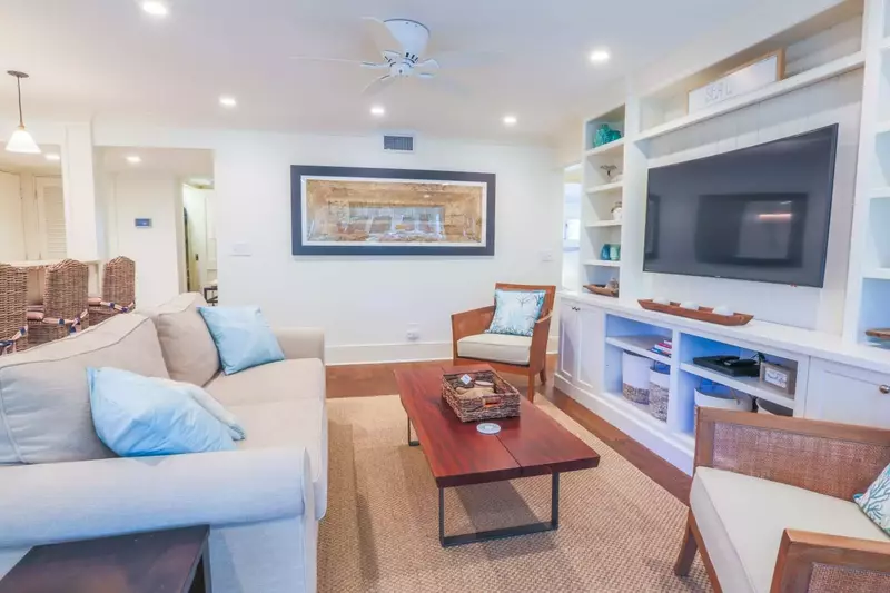 Two of the bedroom suites are to the right of this room.  The third bedroom is to the left of this wall with the artwork.
