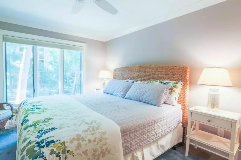 The master bedroom features a king bed, nightstands with reading lamps and ceiling fan.
