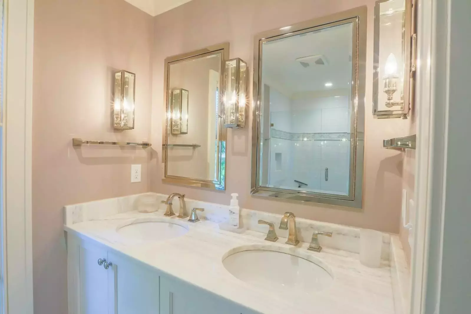 The en suite bath for the master suite has a double sink vanity with white marble countertops.
