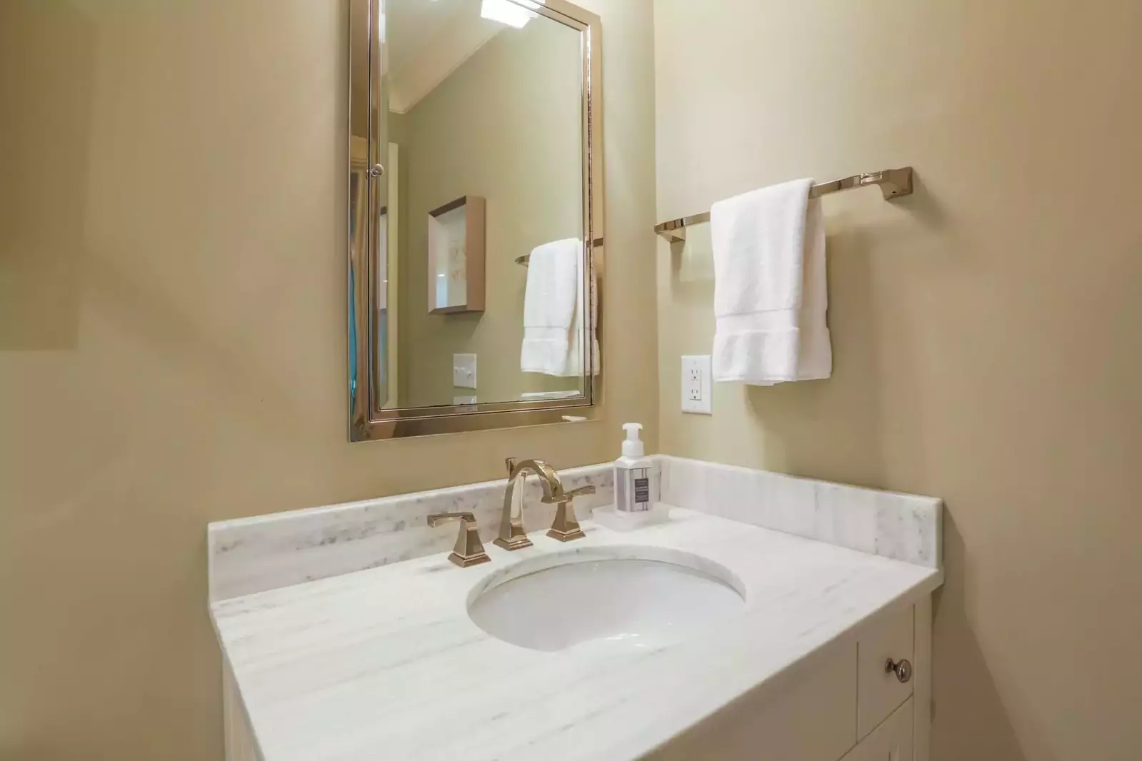This bathroom nearest the twin bedroom has a vanity with white marble countertops.