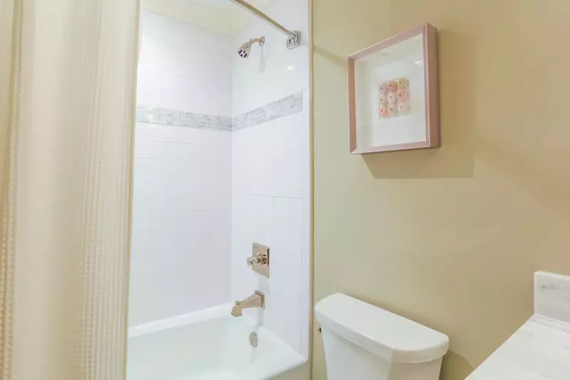 This bathroom also features a tiled shower/tub combo.