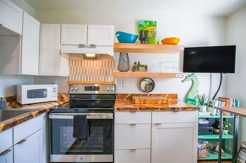 There is a wall-mounted smart TV in the kitchen and dining area.