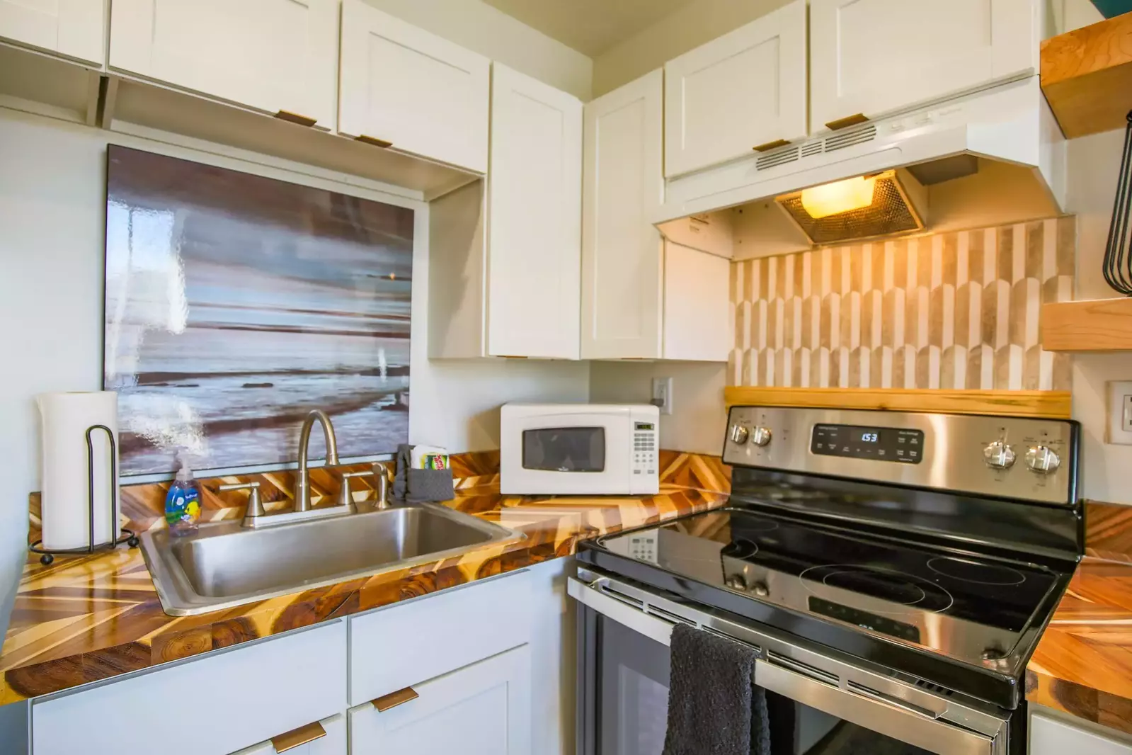 The kitchen is small but mighty with a stove, refrigerator, sink, microwave & coffee maker.
