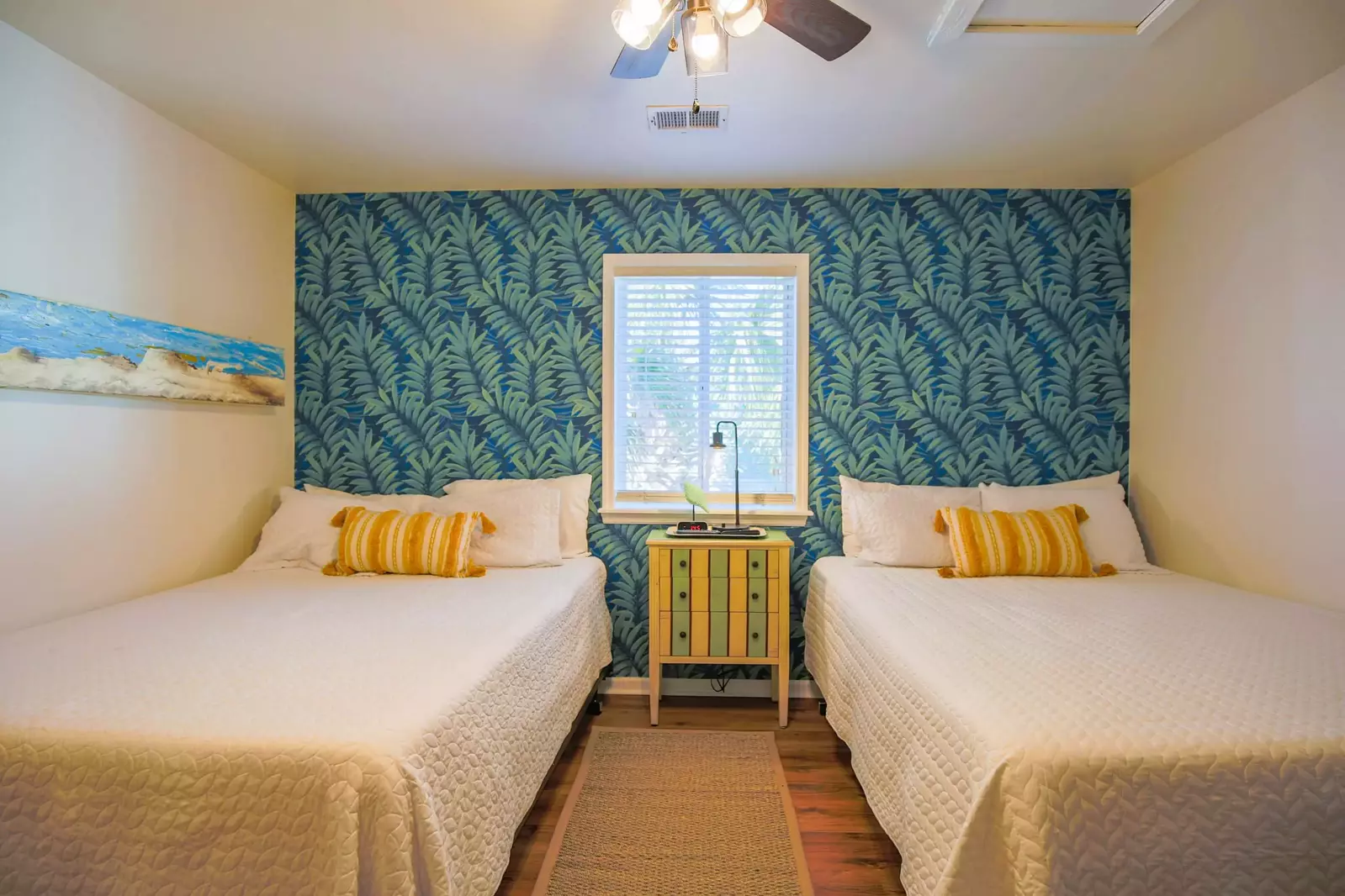There are two queen beds with a nightstand in the bedroom.