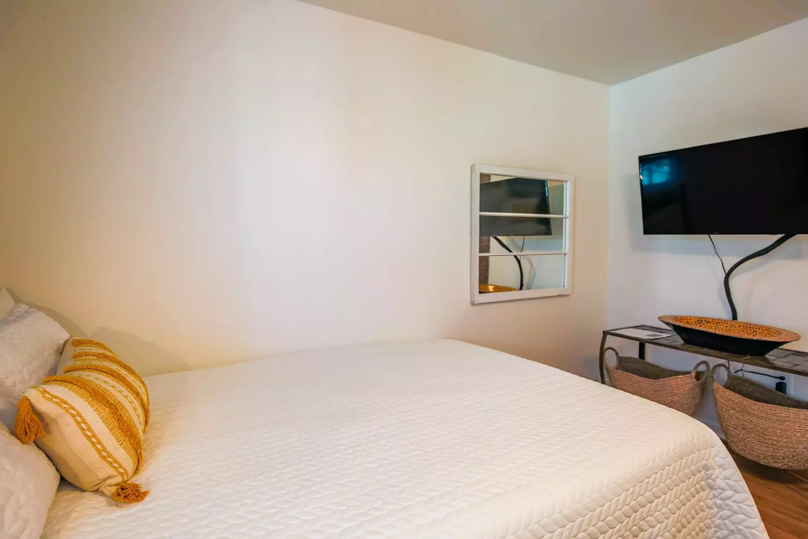 There is a wall-mounted smart TV at the foot of the bed.