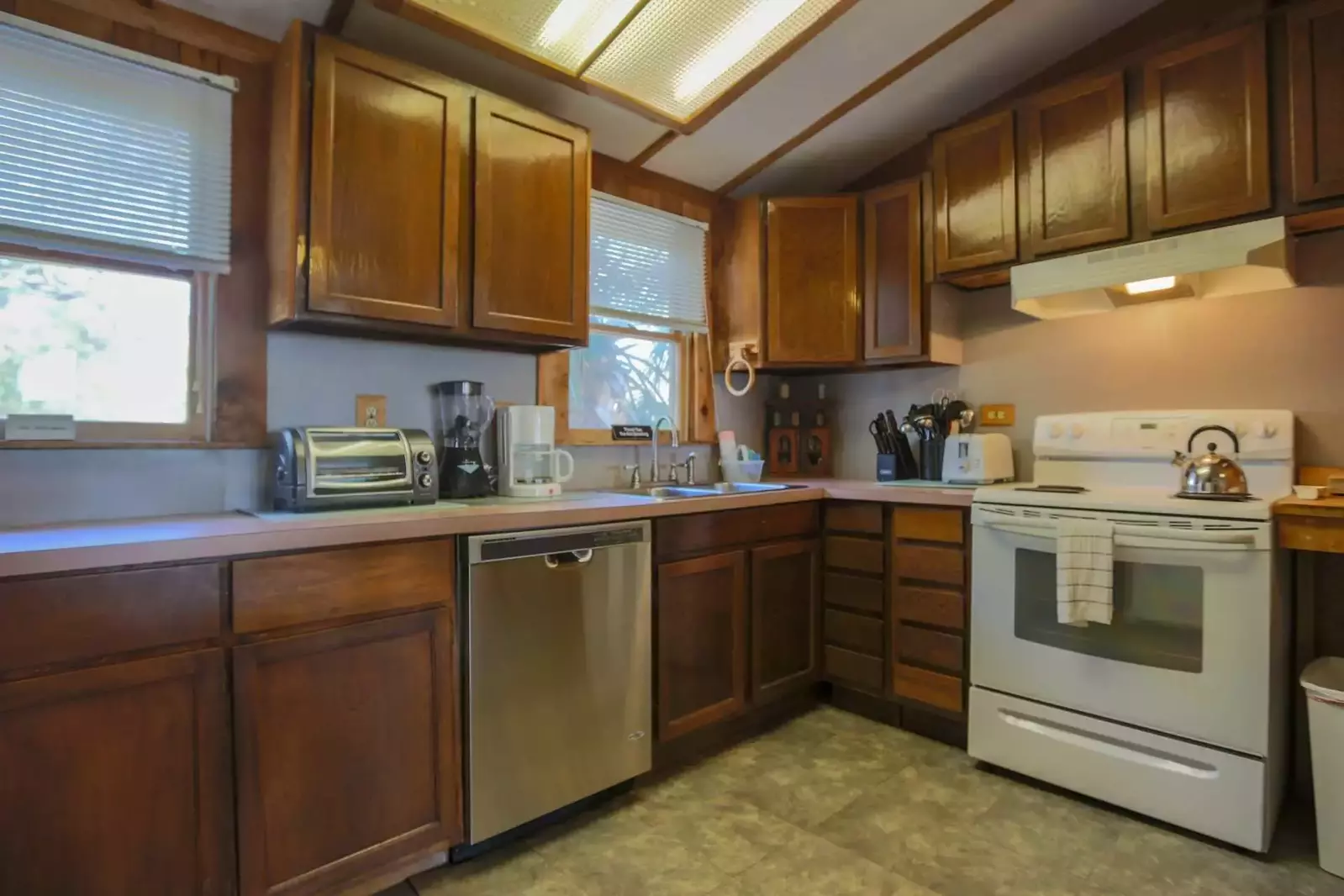 The kitchen features a dishwasher, electric oven & stove, microwave, refrigerator, blender and coffee maker.
