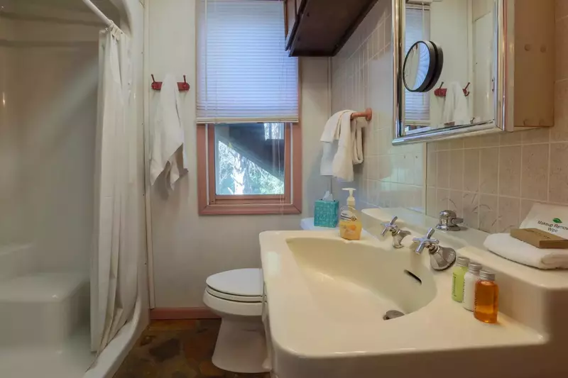 This hallway bathroom features a walk-in shower, soft white towels & a starter set of shampoo, conditioner, lotion & soap.