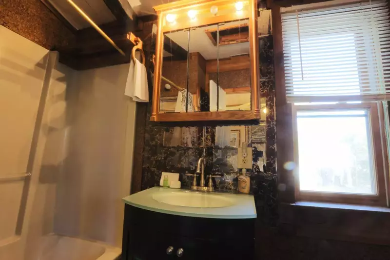 This en-suite bathroom off the guest bedroom has a combined tub & shower and ample storage space.