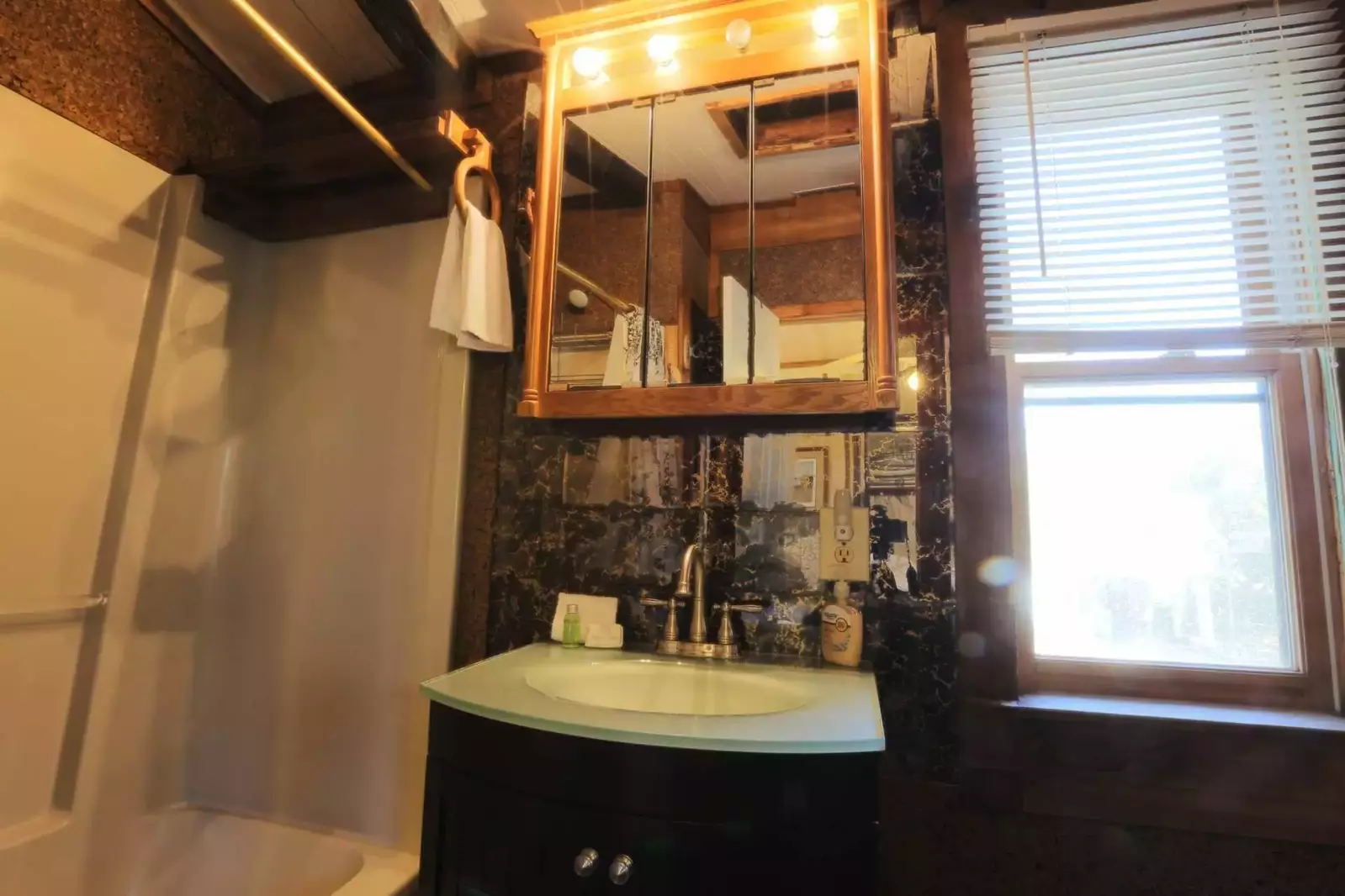 This en-suite bathroom off the guest bedroom has a combined tub & shower and ample storage space.