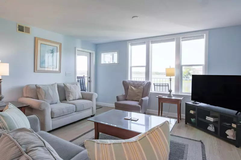 The living room features large, comfy sofas and water views.