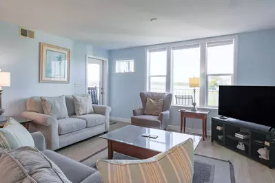 The living room features large, comfy sofas and water views.