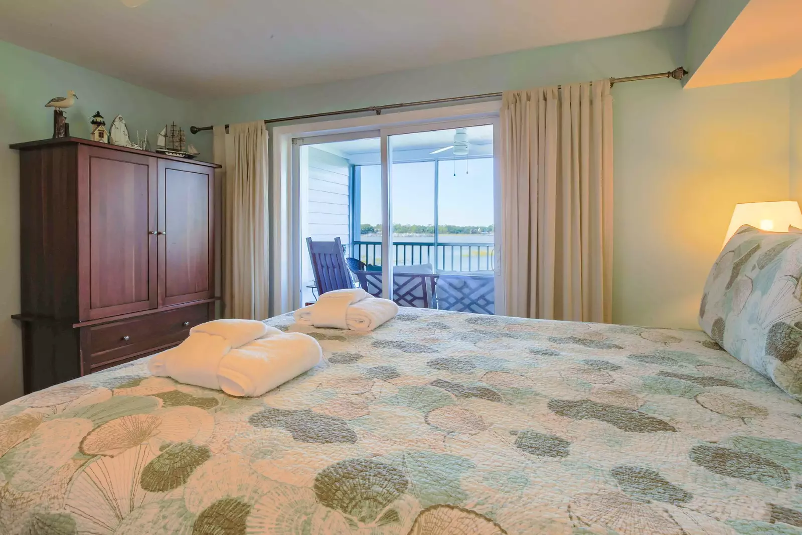 The master suite features water views and sliding door access to the screened porch.