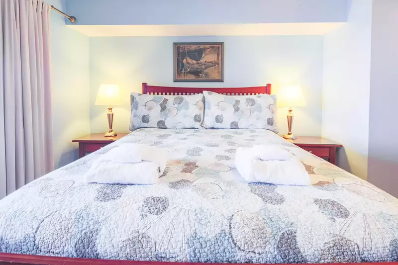 The master bedroom features a queen bed and night stands with reading lamps.