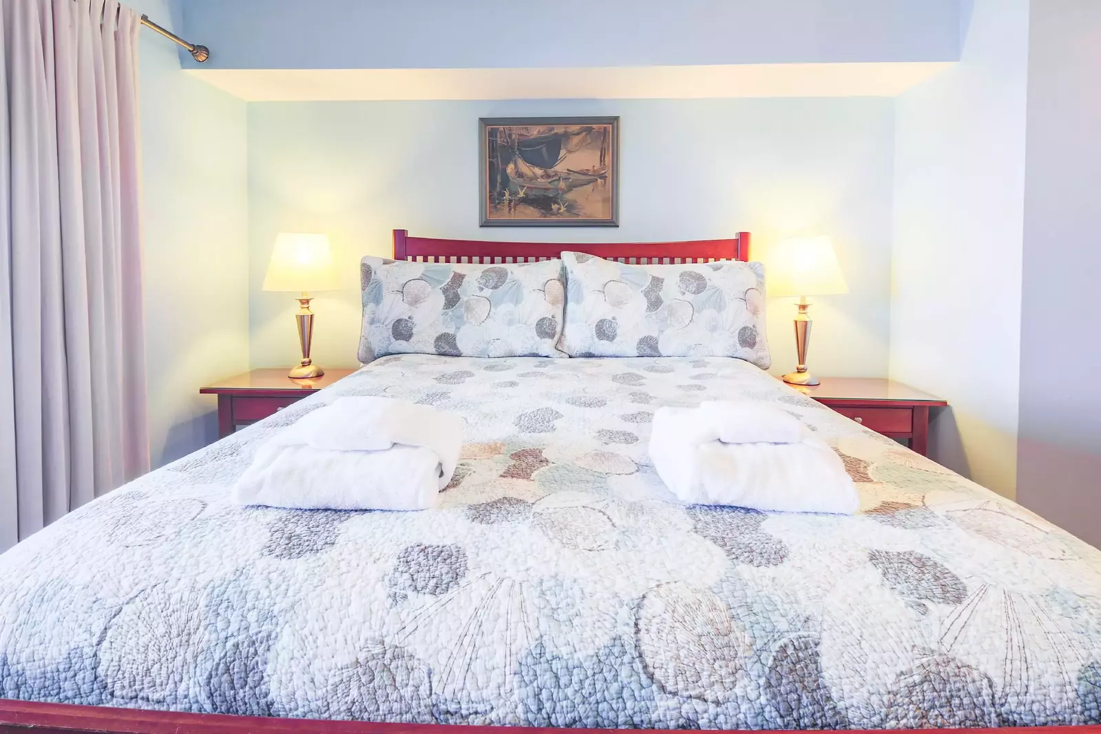 The master bedroom features a queen bed and night stands with reading lamps.