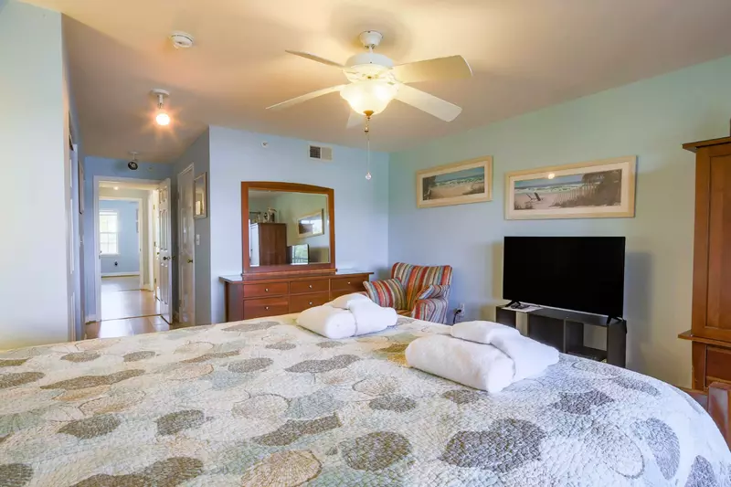 The master suite also has a smart TV, dresser and ceiling fan.