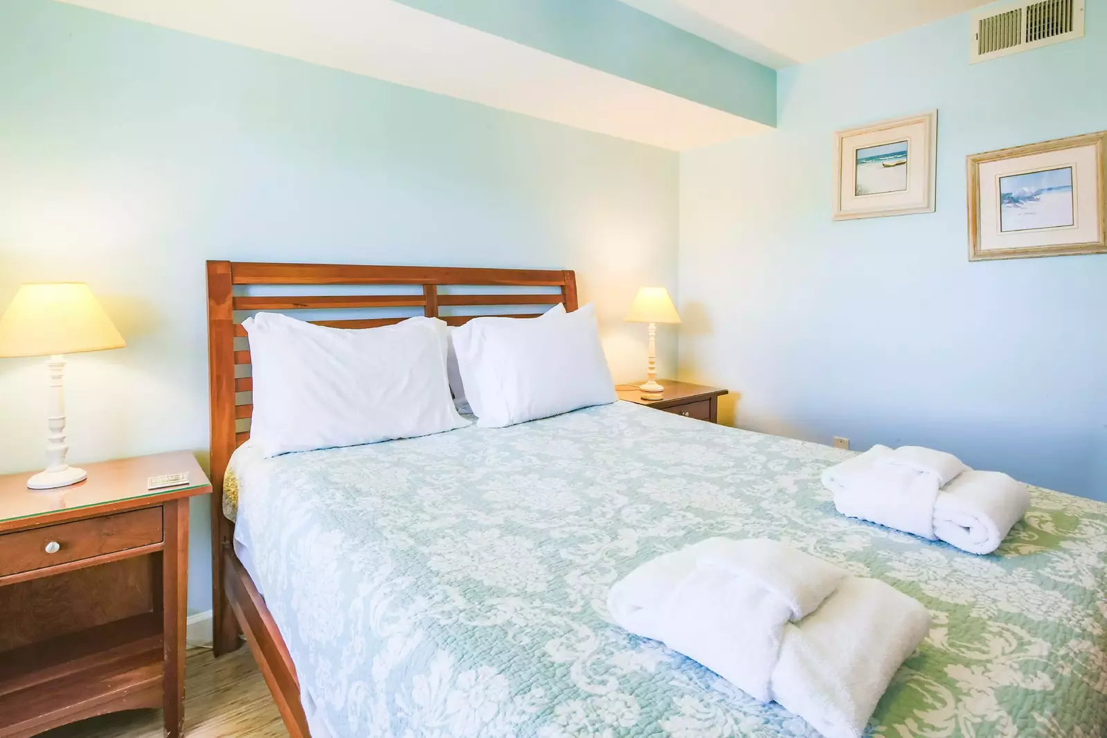 This guest bedroom features a queen bed and nightstands with reading lamps.