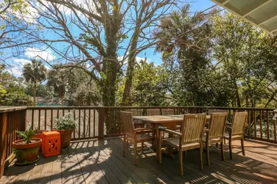 The porch features a teak dining table that comfortably seats 8 people.