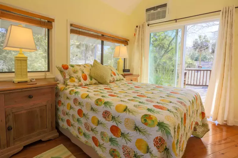 You'll love this sun-drenched guest bedroom with a queen-sized bed, reading lamps and sliding door access to the porch.