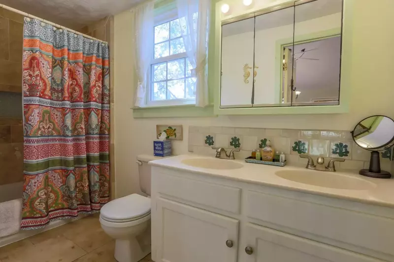The master bathroom features tiled floors, a his & her double-sink vanity and a combined shower & tub.