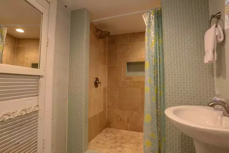 This beautifully tiled walk-in shower is located in the basement bathroom.