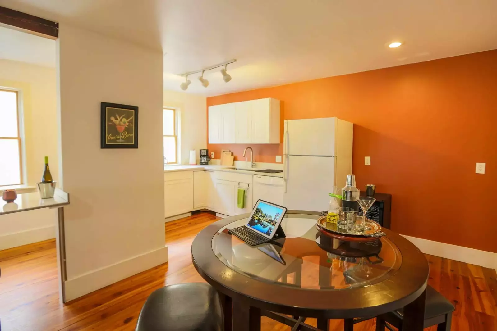 There is also a dining table with four stools near the kitchen.