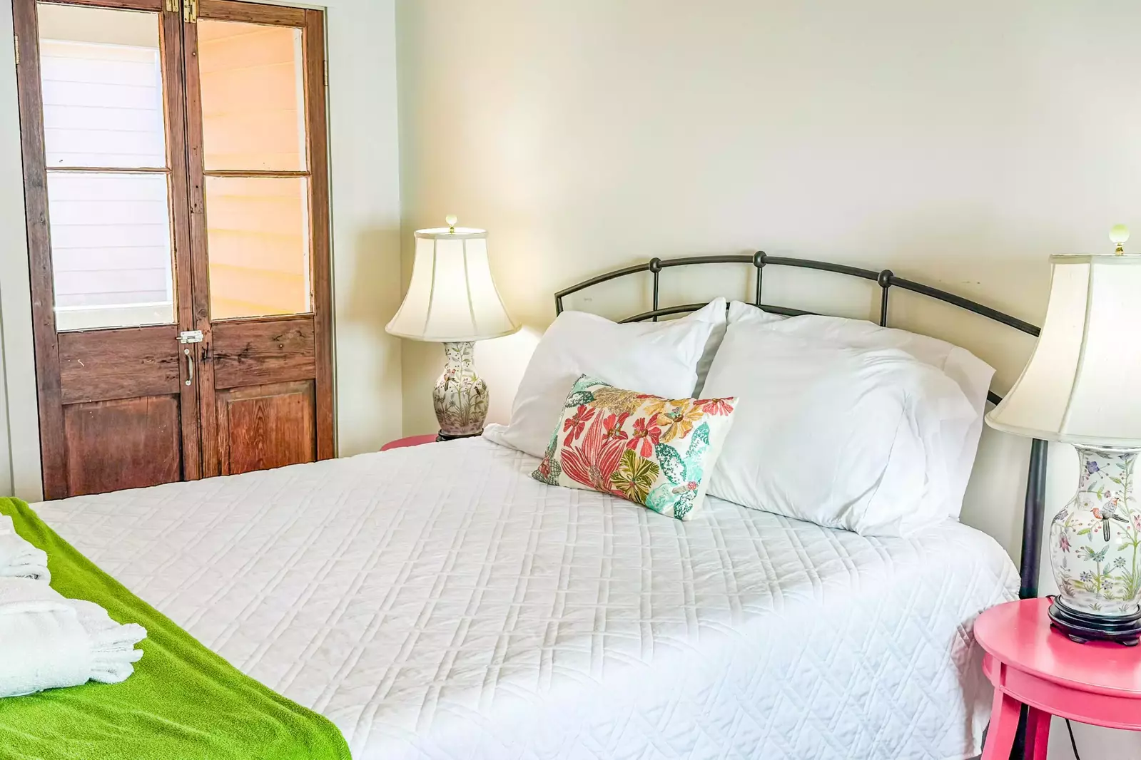 This bedroom features a queen bed and night stands with reading lamps.