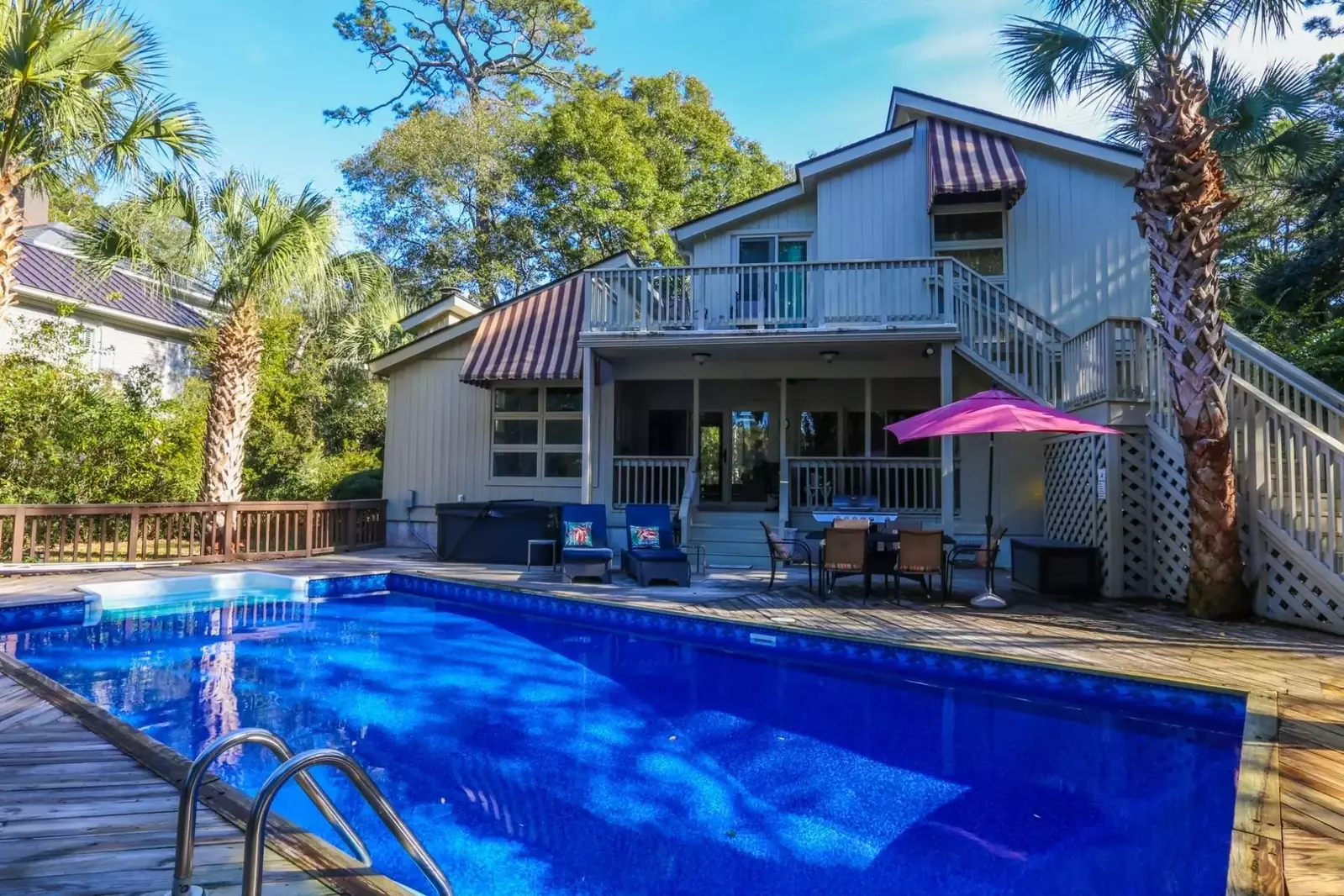 The hot tub is located near the house -- just behind the lounge chairs in this photo.
