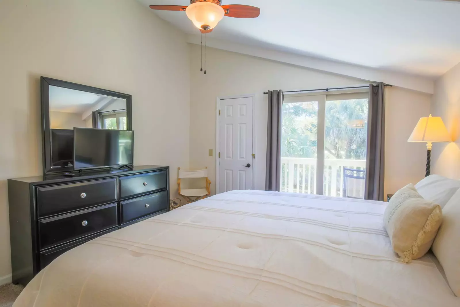 The master bedroom also features a dresser, smart TV and ceiling fan.