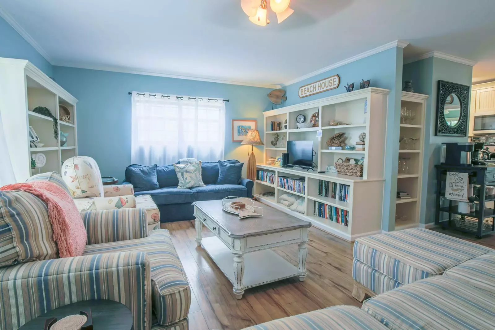 The living room of this vacation home features overstuffed sofa seating with bright, beachy-colored pillows.