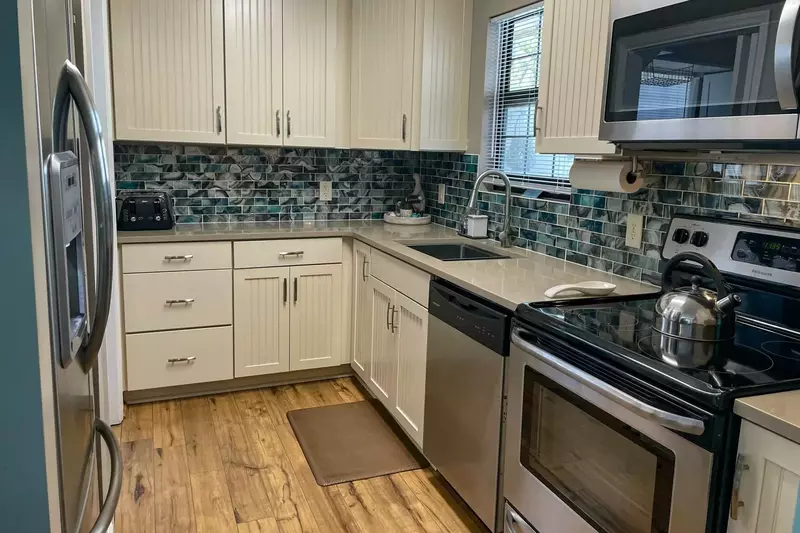 The newly renovated kitchen is equipped with a dishwasher, oven, refrigerator, microwave and toaster.