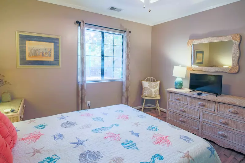This guest bedroom also features a dresser and smart TV.