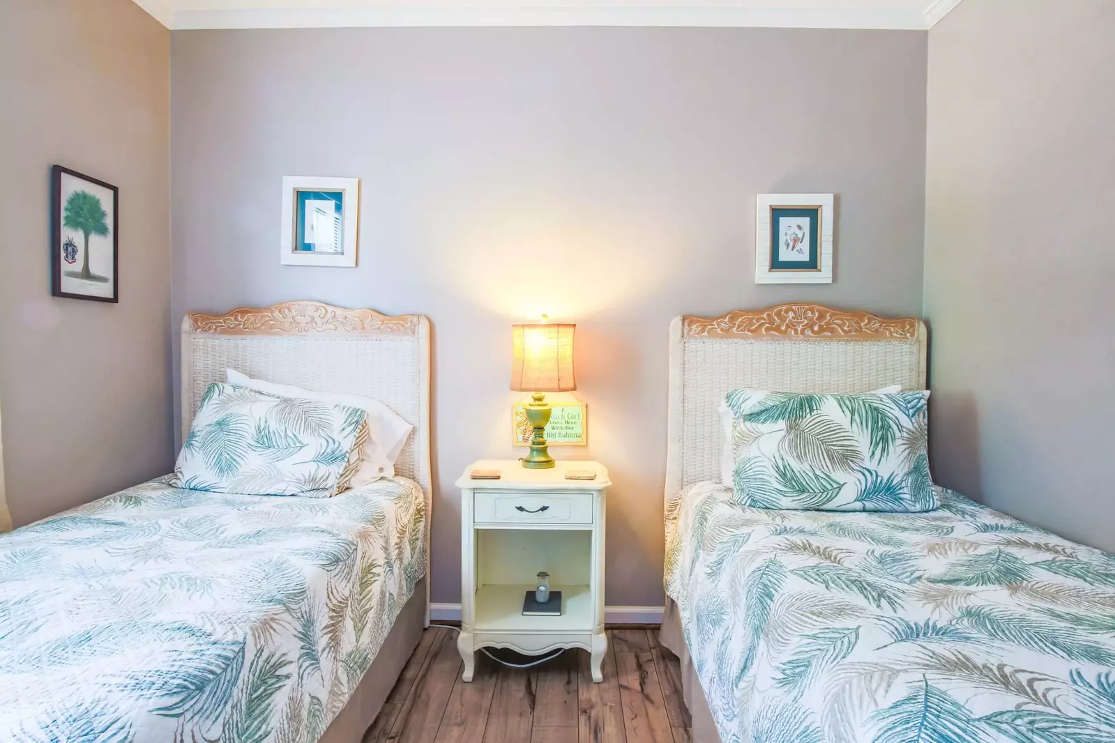 This guest bedroom contains two twin beds, a dresser and nightstand.