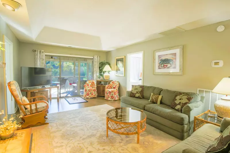 Relax & unwind in this comfortable living room with screened-in porch overlooking the inlet!