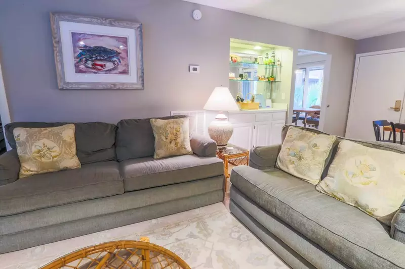 The living room features a seating area with two large sofas.