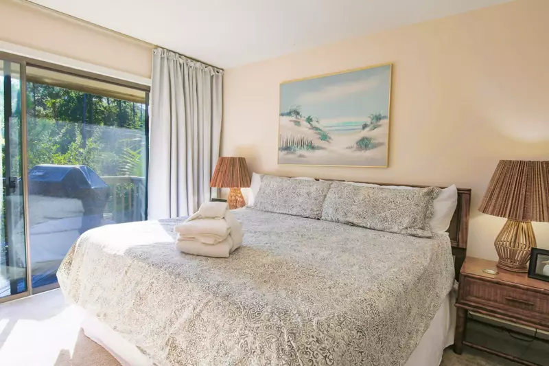The master suite features a king bed, access to the balcony and views of the tidal creek.
