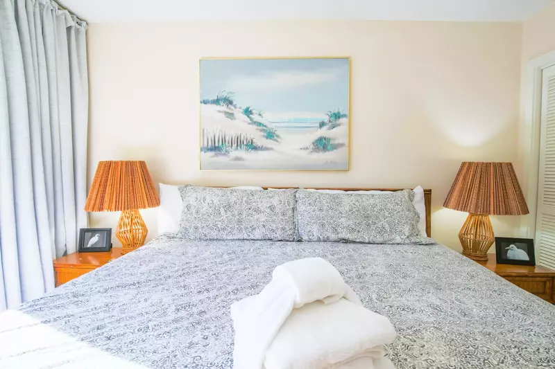 The kind bed in the master suite is flanked by two night stands with reading lamps.